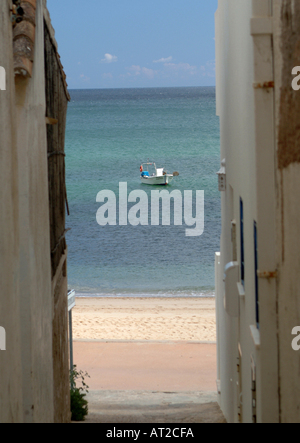 Angelboot/Fischerboot eingerahmt zwischen Häusern in Salema, Portugal Stockfoto