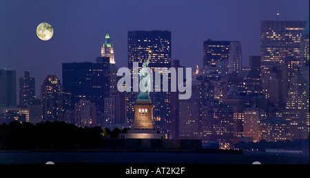 Ein Vollmond steigt über untere Manhattan New York City in dieser Ansicht von Bayonne New Jersey In der Mitte ist die Statue of Liberty Stockfoto