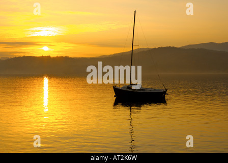 Sonnenuntergang und Segelschiff vor Anker am Lake Windermere, Lake District National Park, Cumbria, UK Stockfoto