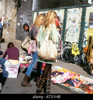 Trendige junge Frau trägt Cowboystiefel in Brick Lane Flohmarkt für gebrauchte und Vintage Kleidung im East End Shoreditch London UK KATHY DEWITT Stockfoto