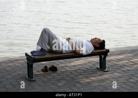 Mann schlafen unter einer Weide, an den Ufern der TaiYe-See im Beihai-Park, Peking, China Stockfoto