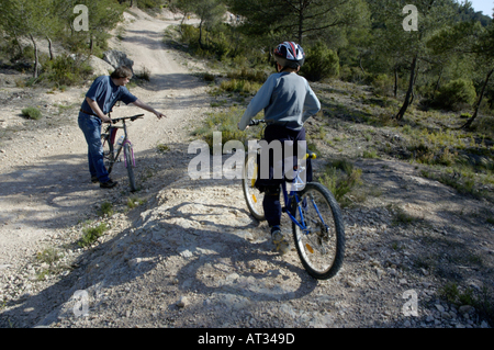 Frankreich Provence Vitrolles Young Boy und Vater S Freund Reiten ihre Mountainbikes auf einem Feldweg Stockfoto