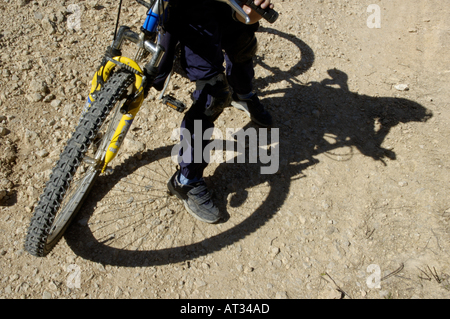 Frankreich Provence Vitrolles Schatten eines kleinen Jungen sitzen auf seinem Mountainbike auf dem Schmutz Stockfoto