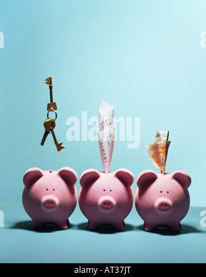 Drei Rosa Sparschweine in einer Zeile, Geld, Schlüssel und Quittungen Stockfoto