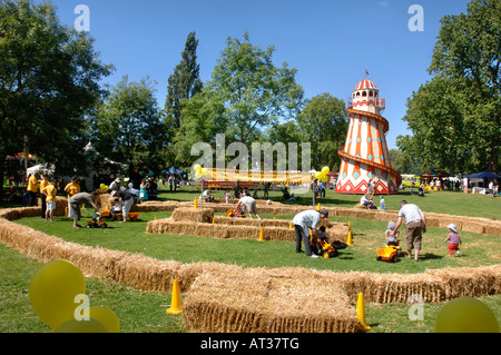 ELTERN HELFEN IHREN KINDERN ZU, AUF SPIELZEUG BAGGER SPIELEN A INNOCENT VILLAGE FETE IM REGENTS PARK LONDON 2007 Stockfoto