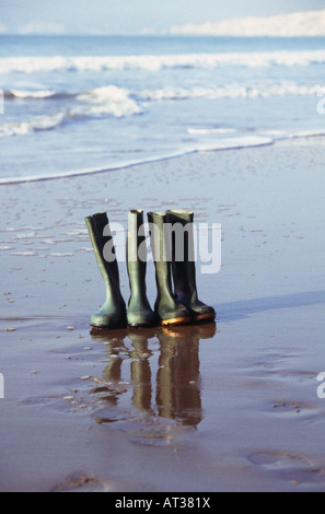 Zwei Paar Gummistiefel aufgereiht am Strand Stockfoto