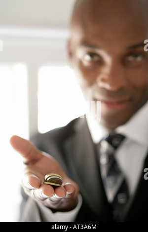 Ein Business-Mann hält eine Handvoll Münzen Stockfoto