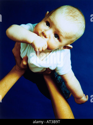 Ein Baby, saugen ihre Daumen in die Luft gehoben Stockfoto