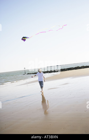 Ein Teenager einen Drachen am Strand Stockfoto
