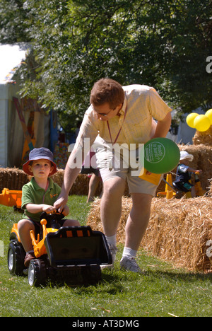 EIN VATER HILFT SEINEM KIND SPIELEN AUF EIN SPIELZEUG BAGGER AN DIE UNSCHULDIGEN DORFFEST IM REGENTS PARK LONDON 2007 Stockfoto