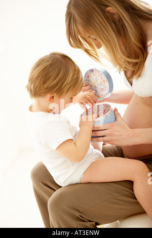 Ein kleiner Junge auf der Suche in einer blauen Geschenkbox Stockfoto