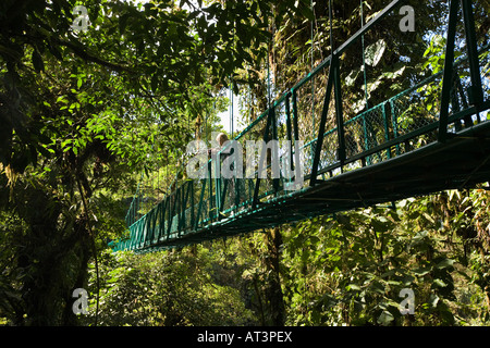 Costa Rica Santa Elena Frau Tourist auf erhöhten Hängebrücke über Baumkronen Stockfoto