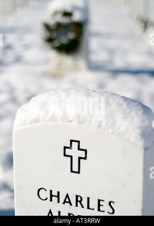 ARLINGTON, Virginia, Vereinigte Staaten – Arlington National Cemetery mit Schnee bedeckt. Die beschauliche Szene zeigt Reihen weißer Grabsteine, die die letzte Ruhestätte des amerikanischen Militärs markieren. Der Arlington National Cemetery ist ein bedeutender Ort der Erinnerung und Ehre. Stockfoto