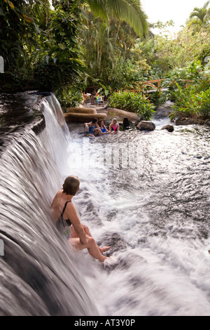 Costa Rica La Fortuna Tabacon Hot Springs Resortgäste sitzen unter thermisch beheizte Wasserfall Stockfoto