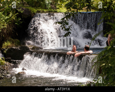 Costa Rica La Fortuna Tabacon Hot Springs Resortgäste sitzen im Pool zwischen thermisch beheizte Wasserfälle Stockfoto