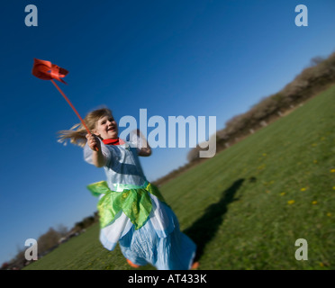 Kind läuft im Park mit Windrad Stockfoto