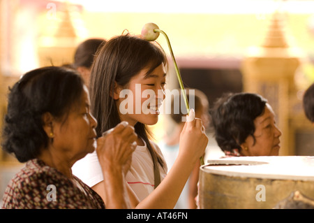 Eine Mädchen berühren eine Lotus Blume Symbol der Reinheit, den Kopf auf dem Gelände des Grand Palace Bangkok Thailand Stockfoto