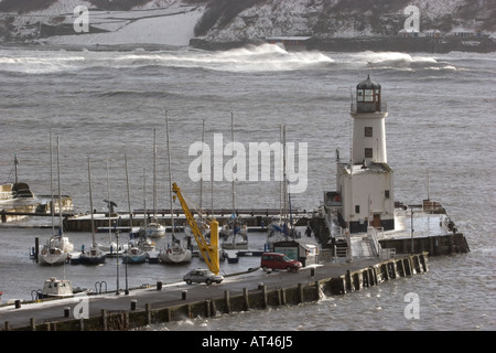 Scarborough-Leuchtturm und Hafen im Winter während der hohen Gezeiten und stürmischem Wetter. Stockfoto