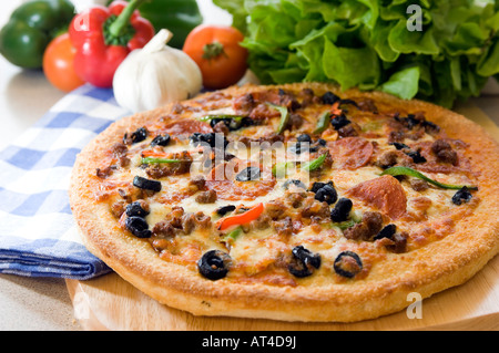 Eine heiße Pizza Torte mit frischen Produkten auf einer hölzernen Platte vorgestellt Stockfoto