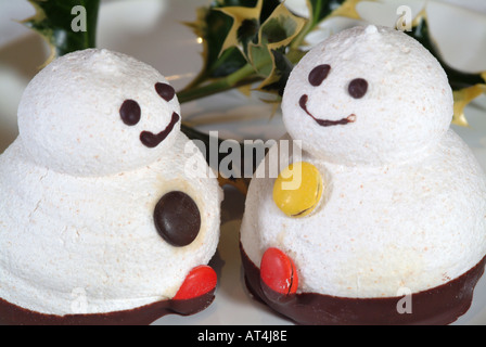 Baiser Schneemänner mit lächelnden Gesichtern und Schokolinsen gemacht für den Weihnachtsmarkt Stockfoto