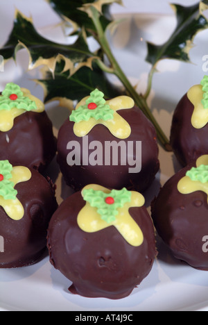 Schokolade Torten wie Christmas Puddings auf einem weißen Teller mit Holly Zweig geformt Stockfoto