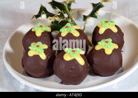 Schokolade Torten wie Christmas Puddings auf einem weißen Teller mit Holly Zweig geformt Stockfoto