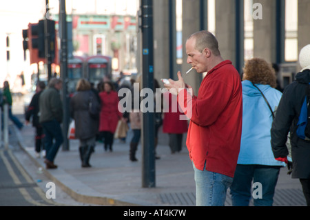 Mann, Zigarette und mit Rauchen auf der Straße Liverpool, England-UK Stockfoto