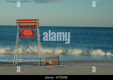 Rettungsschwimmer Stuhl mit einem leeren Mülleimer an einem windigen Nachmittag in Strand von Coney Island Stockfoto