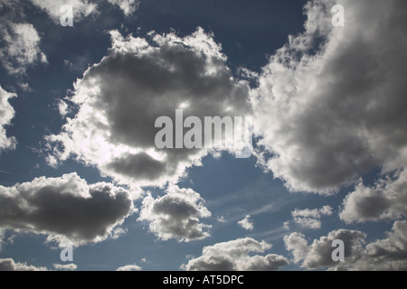 Dunkle Cumulus-Wolken mit hellen Sonne versteckte sich hinter gegen blauen Himmel Stockfoto