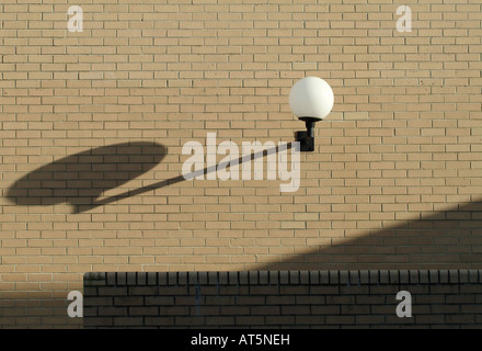 Äußere Leuchte wirft einen Schatten über die Wände eines Gebäudes Stockfoto