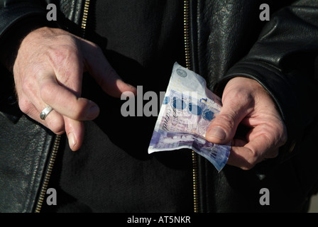 Einer Hand mit Daumen, ein Betrieb eine 20-Pfund-note Stockfoto
