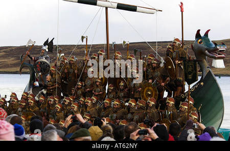 Jarl Roy Leask steht auf der Galeere Brecon in Rüstung mit seiner Mannschaft Stockfoto