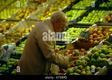 Ein Mann betrachtet man Äpfel im Bereich Obst und Gemüse in einem ASDA Supermarkt in Dewsbury, Yorkshire, England Stockfoto