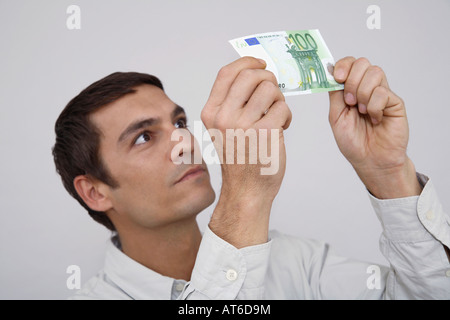 Mann hält Euro-Note, nah-u Stockfoto