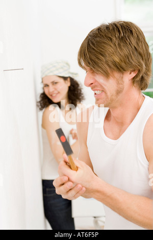 Junger Mann mit Hammer, Daumen auf Close-up Stockfoto