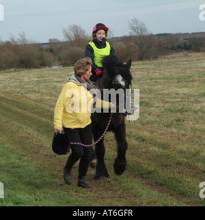 Pony-Reiter und Ausbilder in englischen Landschaft Stockfoto