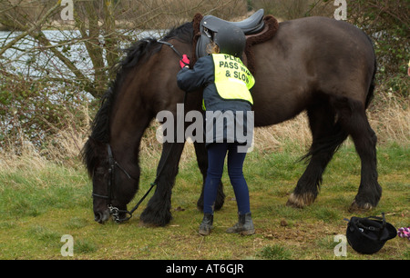 Pony-Reiter tragen Sicherheitsweste eingeschrieben bitte Pass breite langsam kleines Mädchen hält ihr Haustier Cob Pony Stockfoto