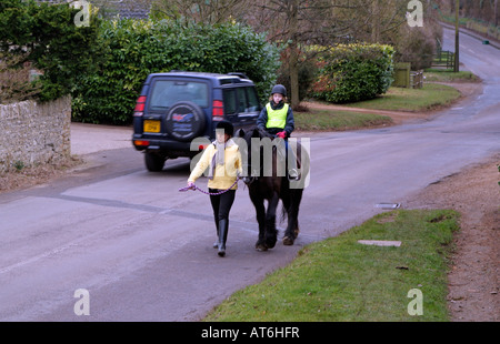 Pony und Reiter tragen eine Bitte Pass breit und langsam Jacke auf Feldweg mit Übergabe Auto England UK Stockfoto