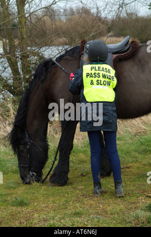 Pony-Reiter tragen Sicherheitsweste eingeschrieben bitte Pass breite langsam kleines Mädchen hält ihr Haustier Cob Pony Stockfoto