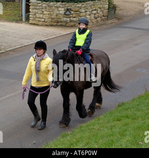 Pony und Reiter eine Bitte Pass breit und langsam Jacke auf Feldweg England Stockfoto