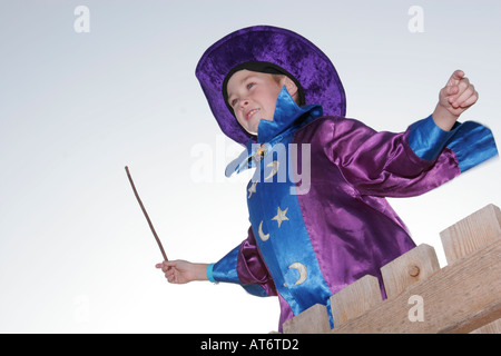 Junge in einem Zauberer Kostüm mit Zauberstab Stockfoto