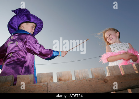 Assistenten junge einen Zauberspruch mit seinen Zauberstab auf blonde Mädchen Holding Federboa Stockfoto