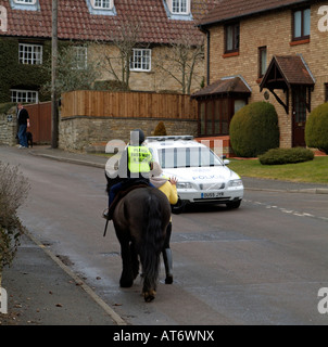 Pony und Reiter tragen eine Bitte Pass breit und langsam Jacke auf Feldweg mit Übergabe Auto England UK Stockfoto