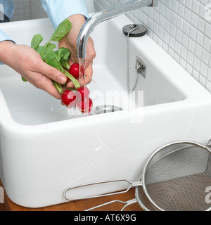 Hand der Reihe von Rettich, Reinigung Nahaufnahme Stockfoto