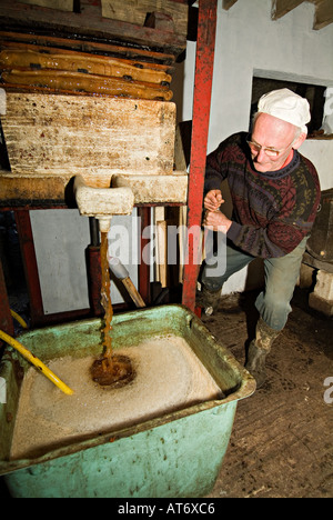 Ein Bauer, der Äpfel in einer kleinen Presse presst, um Apfelwein und Jiuce zu machen. Devon, Großbritannien Stockfoto