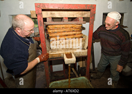 Ein Landwirt, der lokale Äpfel in einer kleinen Handpresse presst, um Apfelwein und Apfelsaft zu machen. Devon, Großbritannien Stockfoto