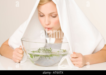 Junge Frau Einatmen Dämpfe, portrait Stockfoto