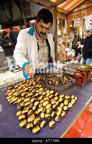 Ein Anbieter von gebratenen Kastanien eher seinem Stall in einer Straße in Istanbul. Stockfoto