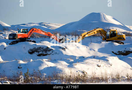 Zwei Bagger Kopf an Kopf auf verschneiten Hügel, Finnland Stockfoto