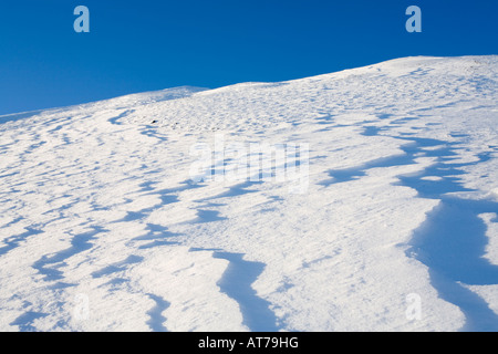 Wind bildete Muster auf einem schneebedeckten Hügel im Winter, Finnland Stockfoto
